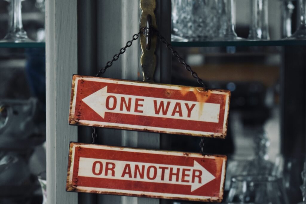 Two vintage arrow signs pointing opposite ways reading one way or another, illustrating the choice between Keystart, the 5 per cent deposit scheme and a bank loan for a first WA home