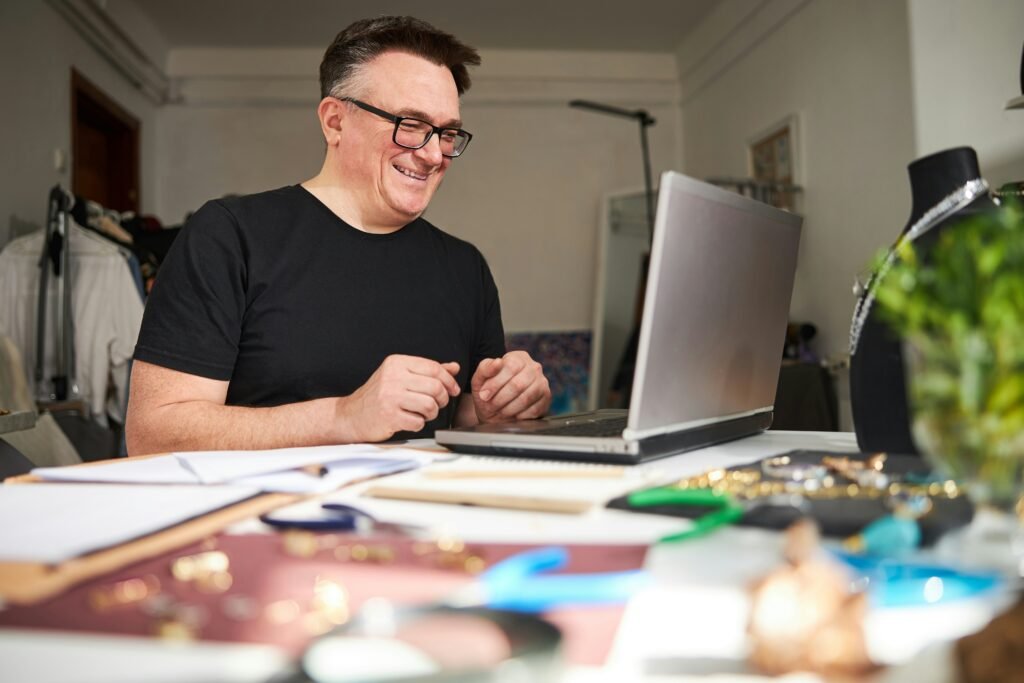 Jewellery maker at his workbench checking his laptop, a small business that suits a business loan using bank statements