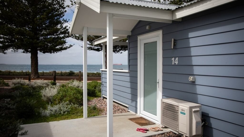 Blue weatherboard beach cottage by the WA coast, an affordable home a rentvesting buyer might own while renting where they want to live