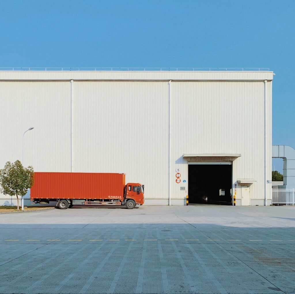 ruck parked outside a warehouse with its roller door open, the kind of business real property an SMSF commercial property loan can buy